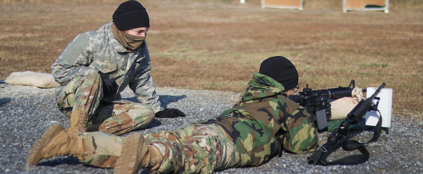 A cadet shoots an M4 at a semester field training exercise