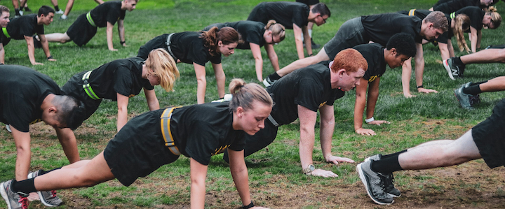 Cadets are poised at the front leaning rest position at physical training.